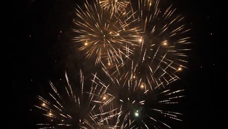 golden fireworks display on dark sky - slow motion