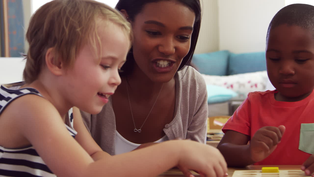 maestro y alumnos usando formas de madera en la escuela montessori