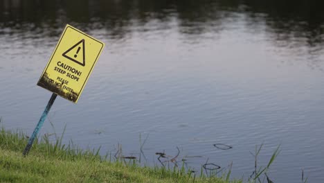 sign swaying gently by a tranquil pond.