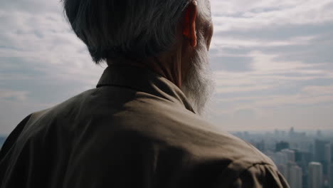 elderly man looking at city view from high building