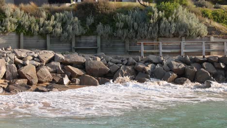 waves hitting rocks along a coastal barrier