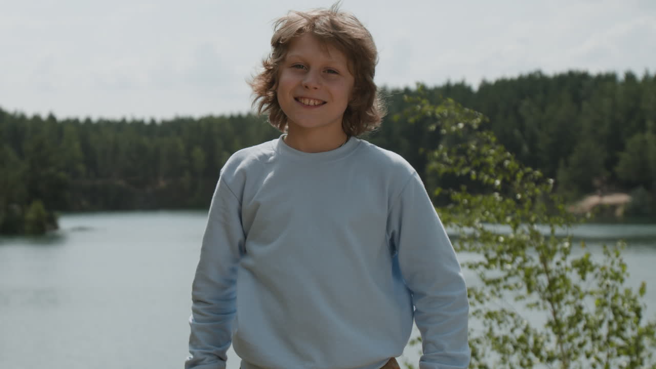 Boy smiling by a lake