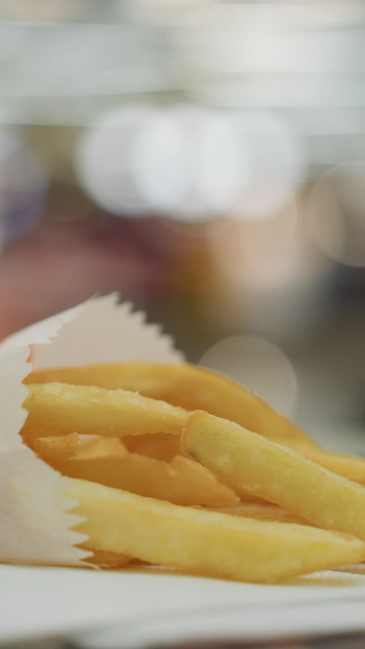 Close-up of golden French fries on a table with a blurred background. appetizing appearance of the fries in a casual dining setting