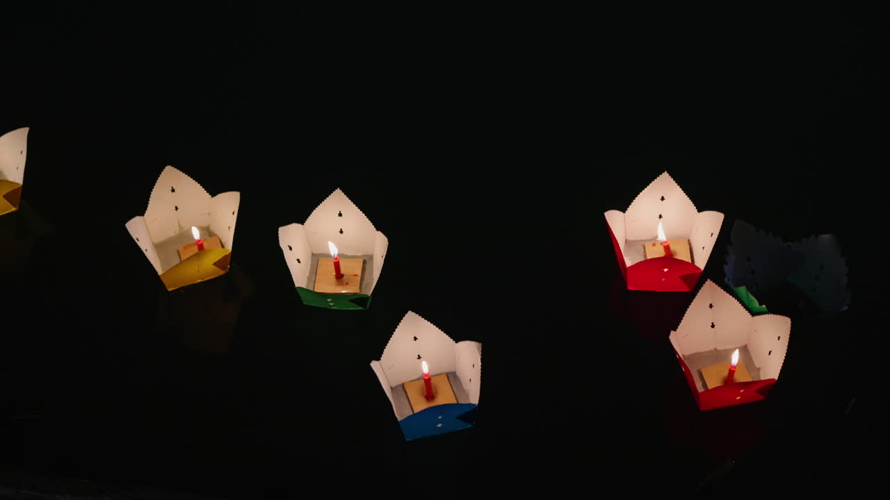 4K close‑up of colourful paper lanterns floating serenely on the river at night in Hoi An