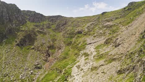 smooth aerial descent past the cliff faces of mount snowden in snowdonia national park in wales - glacial landforms makes for challenging hiking trails for visiting adventurers and tourists