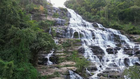 aerial descends to base of beautiful mae ya waterfall in thailand