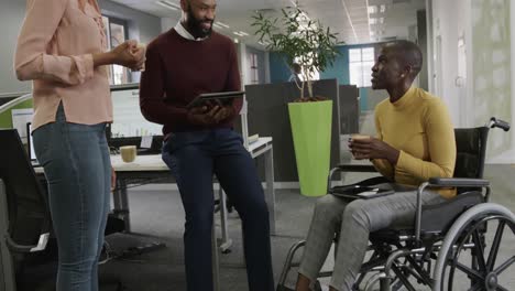 colegas de negocios afroamericanos discutiendo el trabajo en la oficina, una mujer en silla de ruedas, cámara lenta