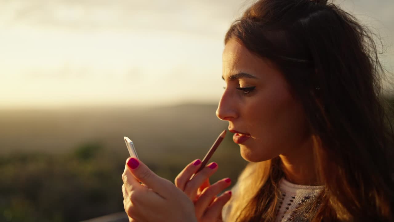 disparo de cerca en cámara lenta de una modelo dibujando sus labios antes de su disparo