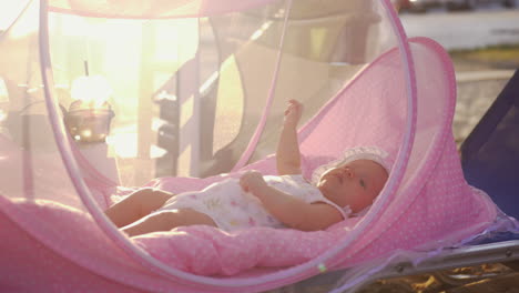 baby in pink bassinet outdoor in summer
