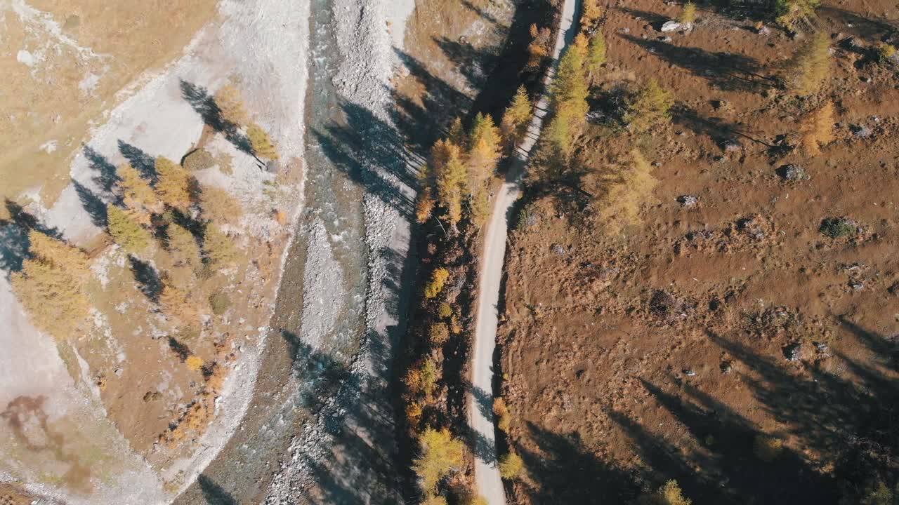 a winding river a long side a dirt road