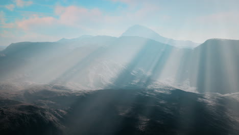 majestic mountain range with sun rays breaking through the fog