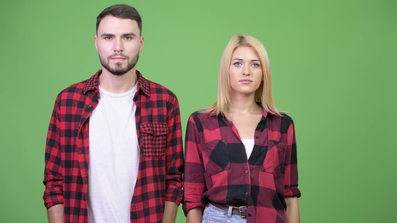 Young couple together against green background