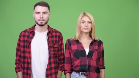 young couple together against green background