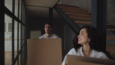 Smiling-man-and-woman-caring-paper-boxes-in-slow-motion.