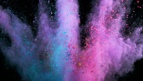 super slow motion of colored powder explosion isolated on dark background.