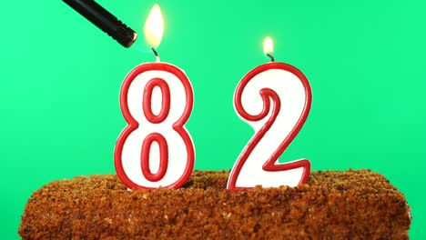 cake with the number 82 lighted candle. chroma key. green screen. isolated