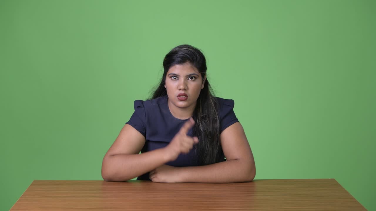 joven sobrepeso hermosa mujer de negocios india contra fondo verde