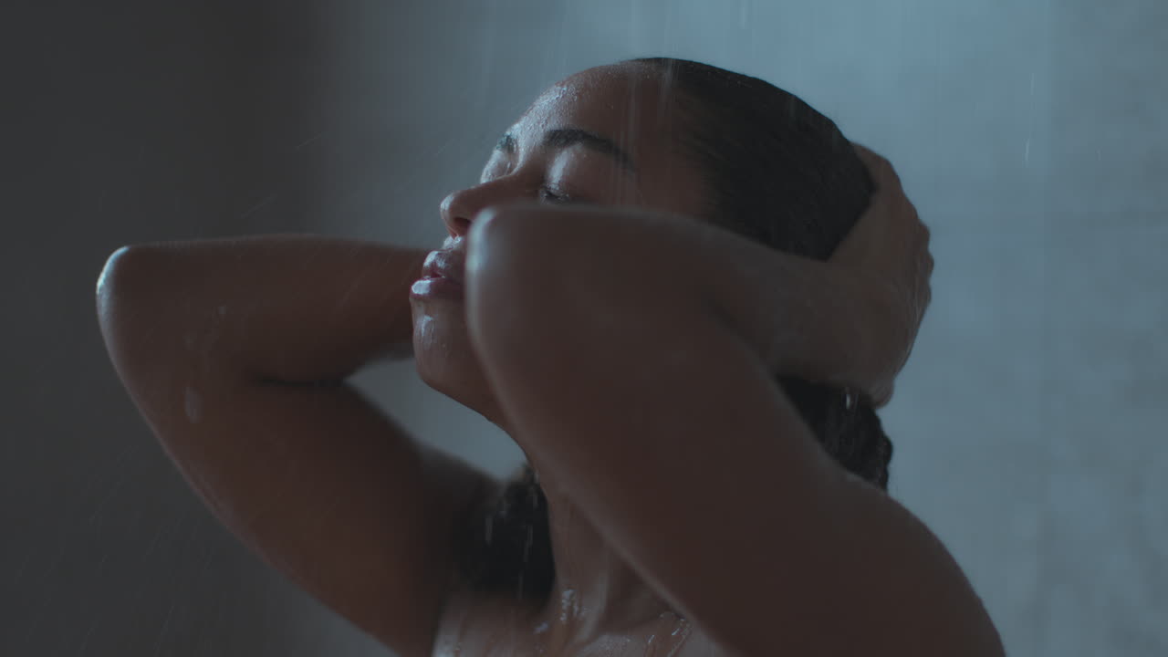 여자 가 샤워실 에서 머리 를 고 있다