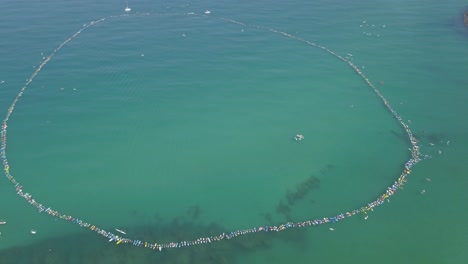 massive circle of stand-up paddleboarders