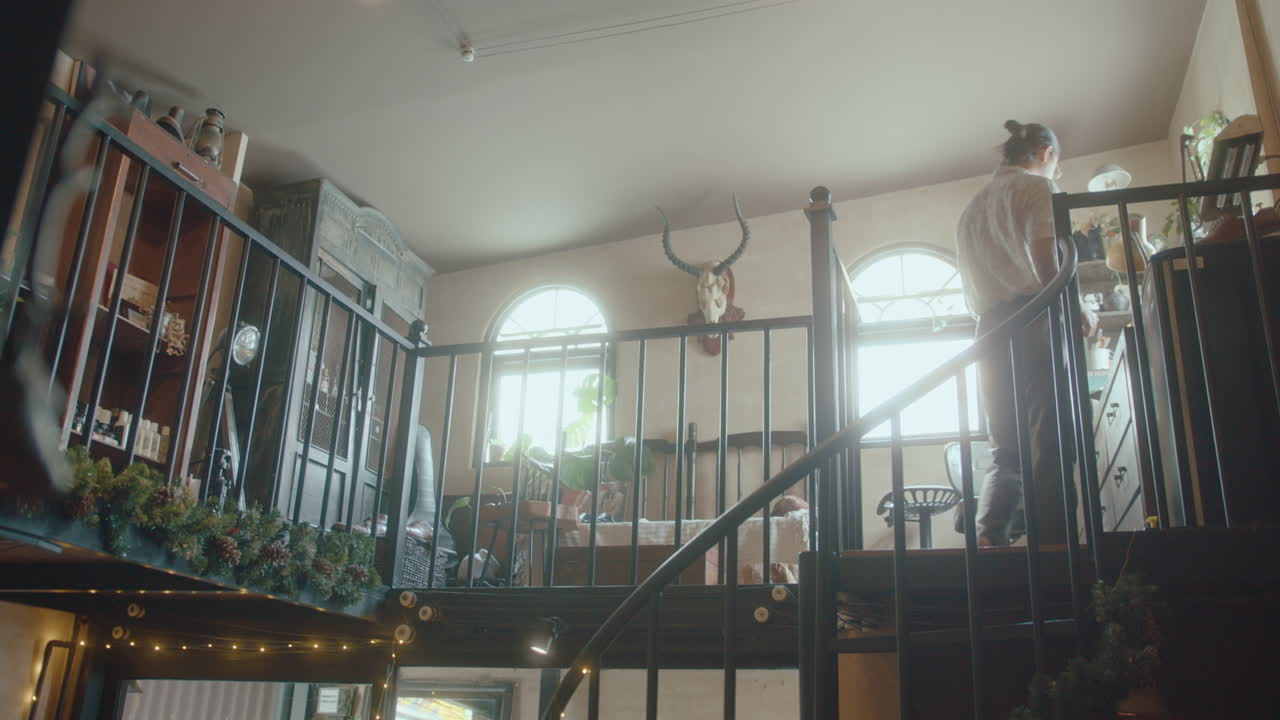 Asian Man Walking Upstairs in Antique Store with Christmas Decor