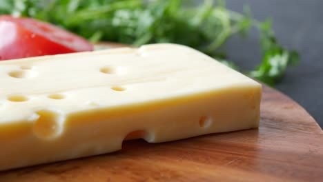 Sliced-cheese-with-holes-on-a-chopping-board-on-table