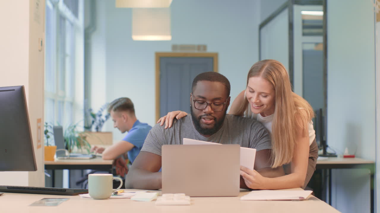 Business woman explaining project to colleague. Happy couple smiling