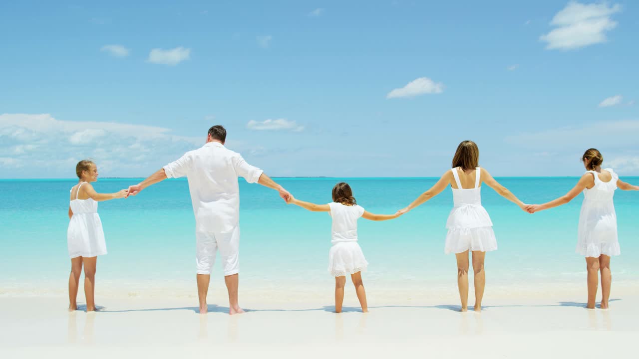 백인 부모 와 그 들 의 여자 자녀 들 이 해변 을 즐기고 있다