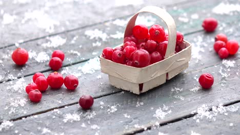 fresh cranberries in a basket on the table and snow