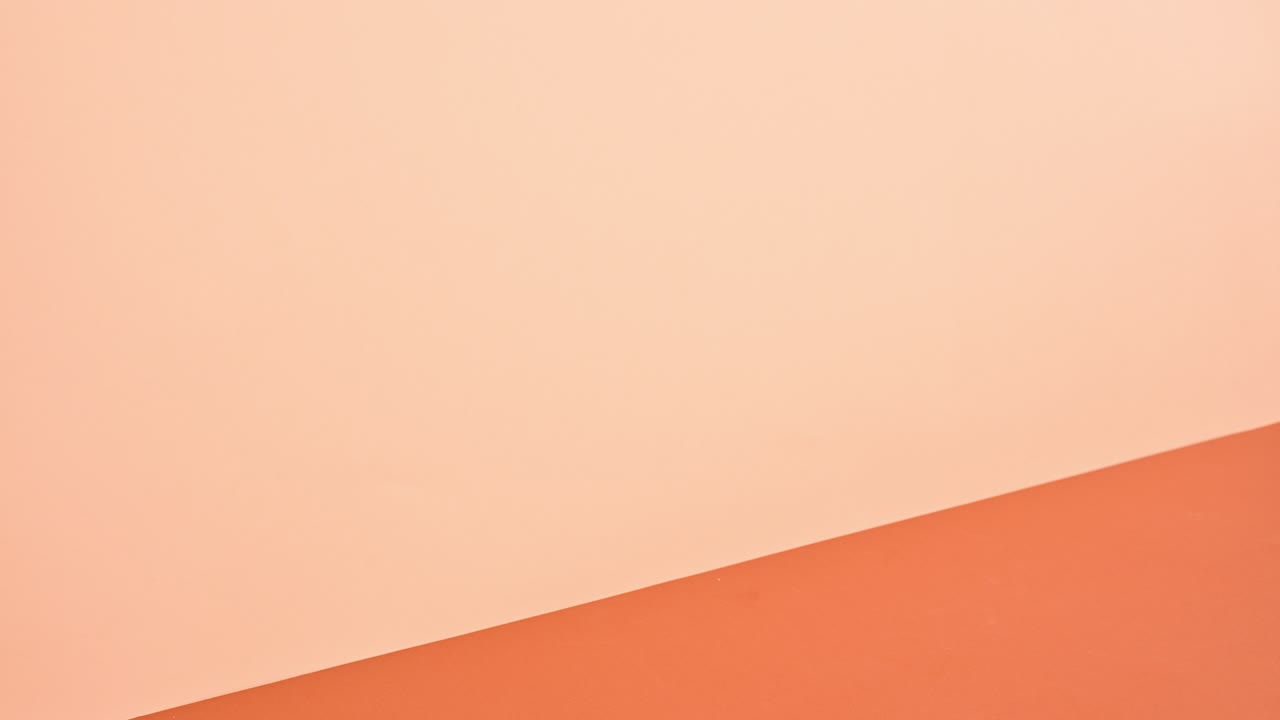 globo terrestre dorado saltando en en la pila de libros contra el tema naranja profundo y brillante. detener el movimiento