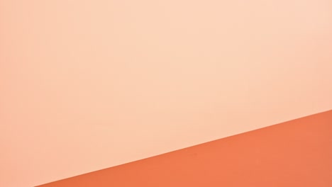 gold earth globe jumping on on stack of books against deep and bright orange theme. stop motion