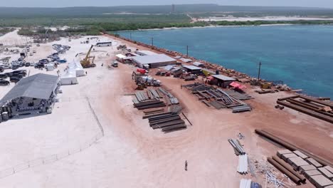 Aerial-view-of-construction-site-with-pipes,-steel-and-industrial-machinery-at-terminal-port-of-Cabo-Rojo