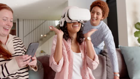 using vr headset, woman laughing with female friends, holding smartphone, enjoying hangout