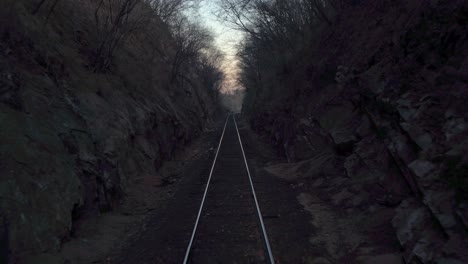 pov of a moving train passing through a narrow scary scenery