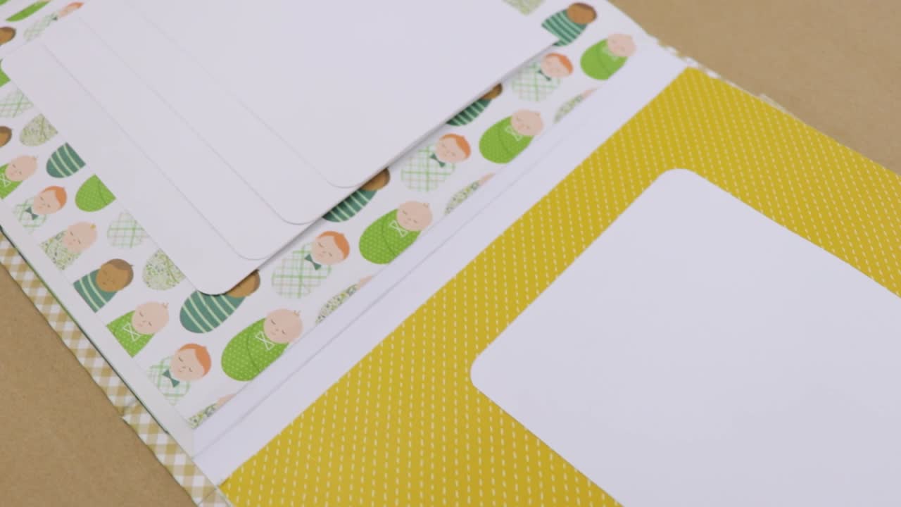 Baby themed scrapbook album with cute illustrations and green accents, ideal for capturing precious memories