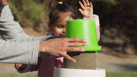 Father-Lifts-The-Green-Bucket-With-His-Daughter-Happy-And-Clapping-As-He-Reveals-The-Sand-Cake-In-The-Beach