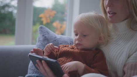 mother and son looking at smart meter at home during cost of living energy crisis