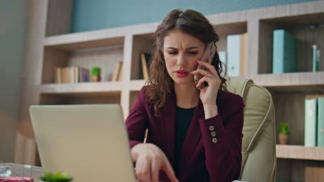 worried businesswoman communicating smartphone in corporate office closeup.