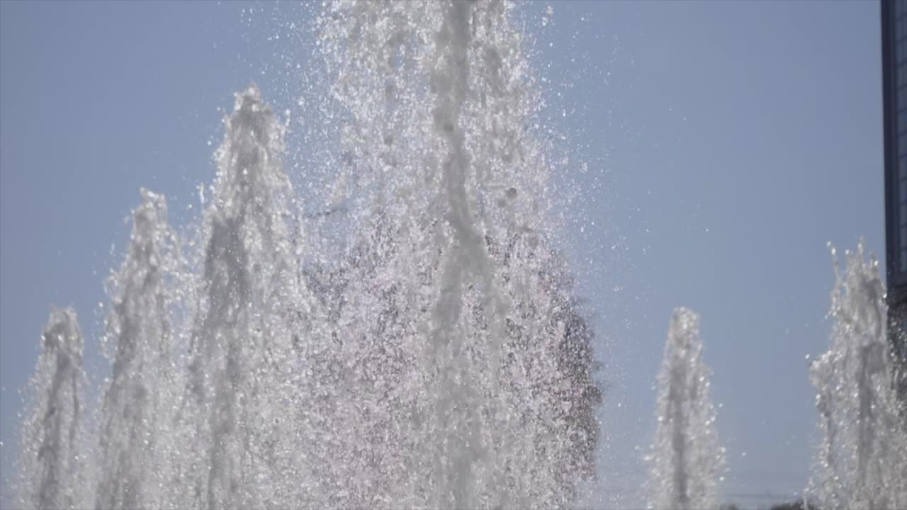 las poderosas plumas de chorro hacen una brillante cascada en la fuente de agua que se inclina lentamente hacia arriba
