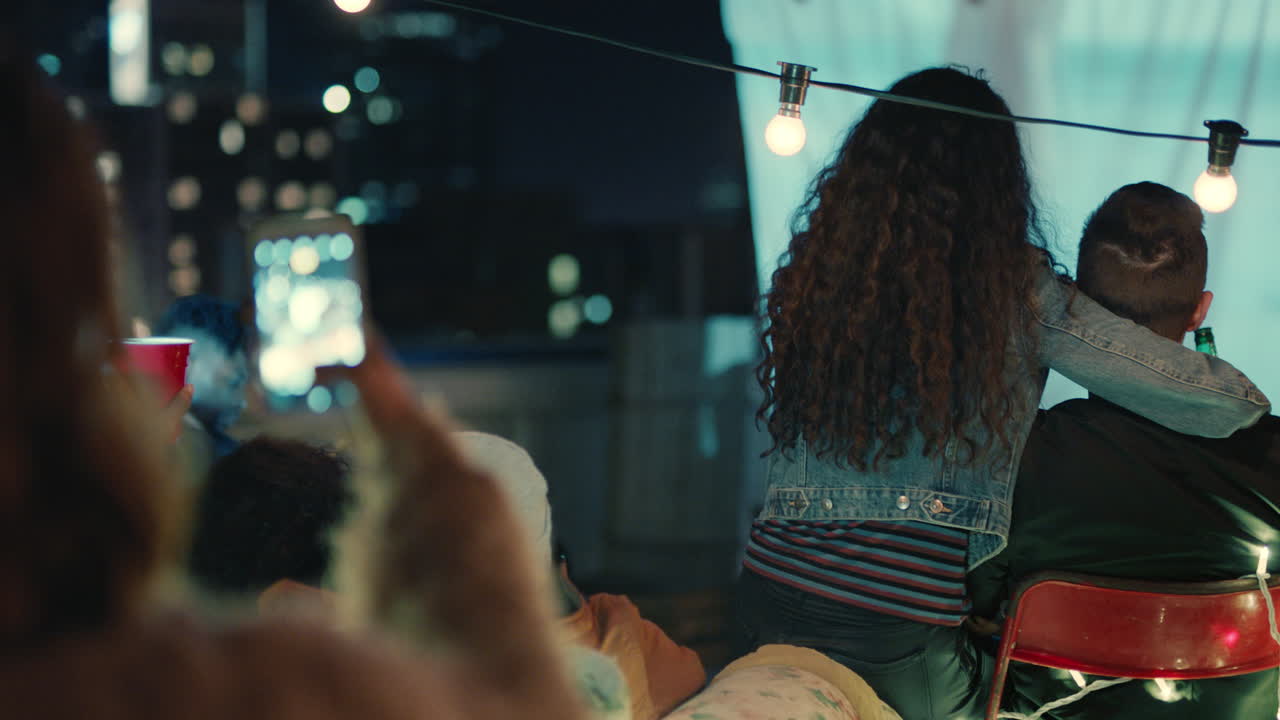 grupo de amigos diversos viendo una película en el cine de la azotea pasando el rato juntos disfrutando de la fiesta de reunión de fin de semana en la ciudad urbana por la noche