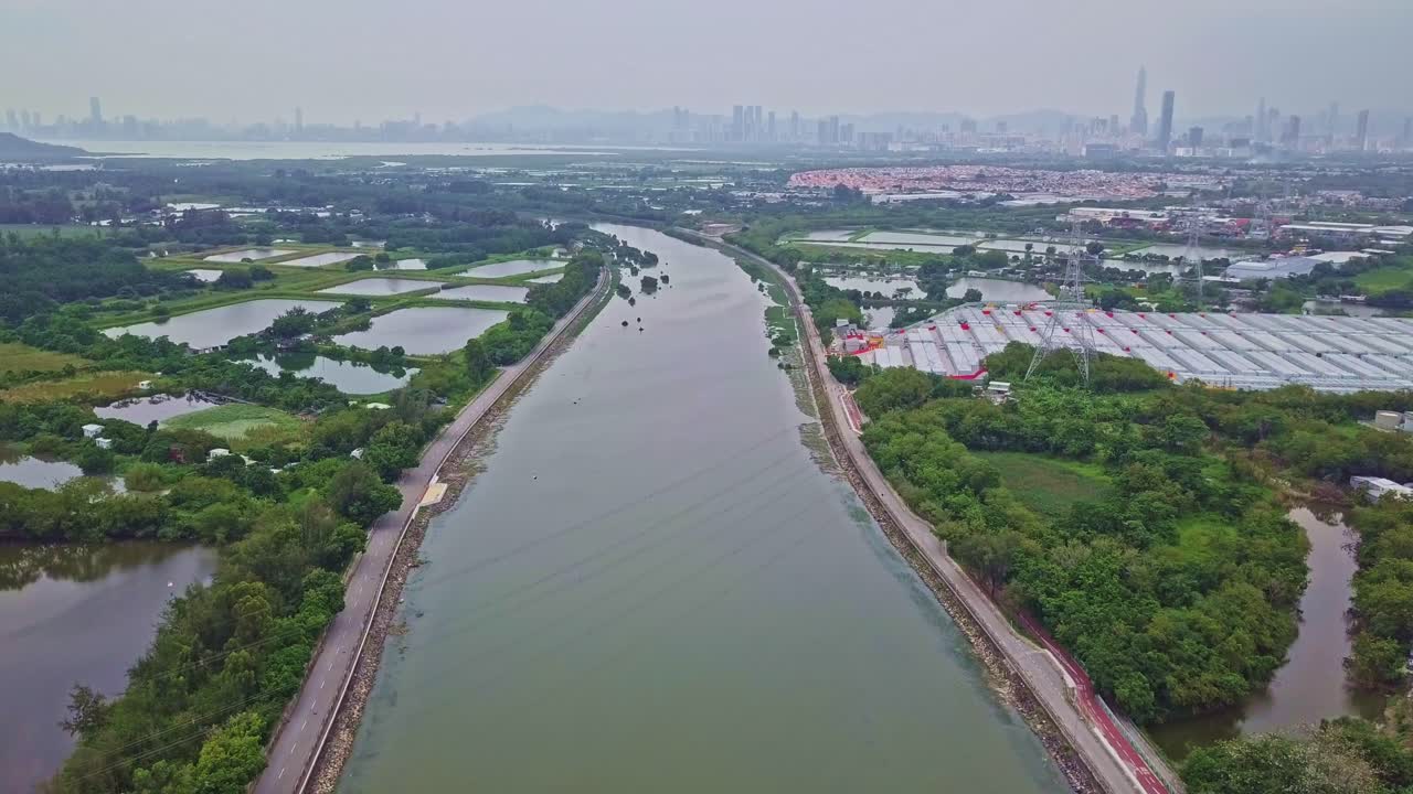 un metraje aéreo ascendente dinámico sobre el río shan pui en yuen long, hong kong