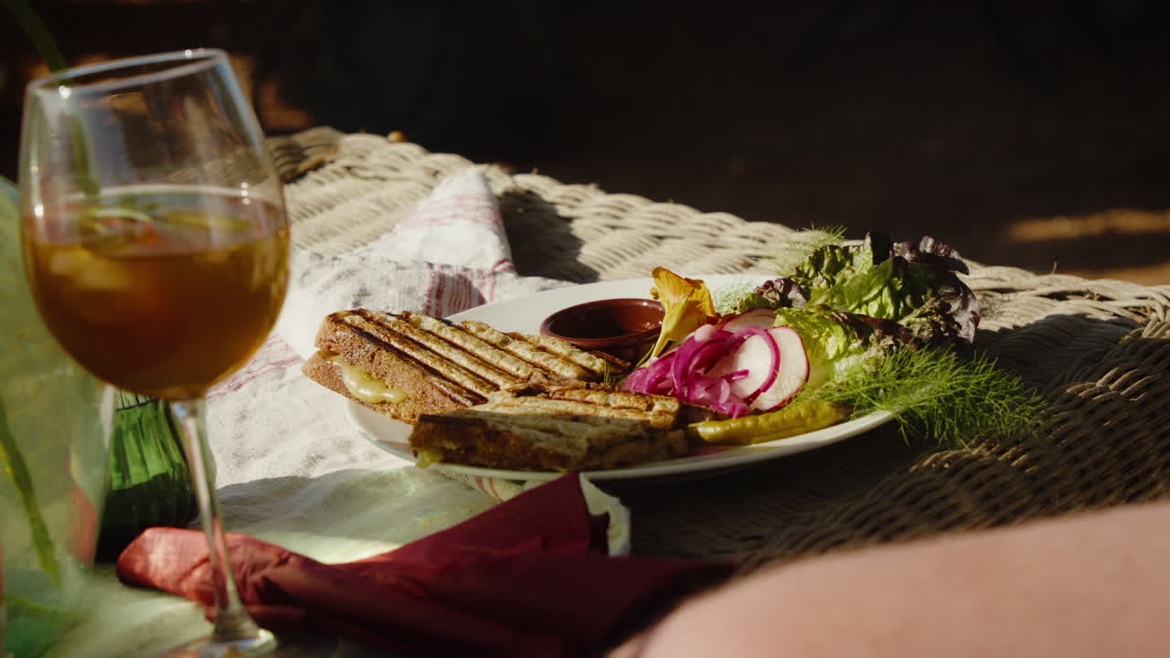 Delicious grilled sandwich on rustic wicker table with fresh salad. Perfect for culinary videos or lifestyle blogs showcasing rustic dining experiences.
