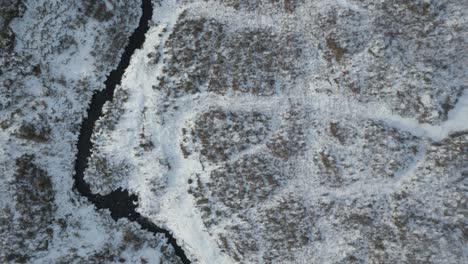 Toma-Aérea-Del-Puente-De-Skye-Y-Sus-Alrededores-En-Escocia-Con-Un-Paisaje-Cubierto-De-Nieve-Y-Un-Río-Sinuoso.