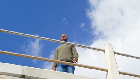 Low-angle-view-of-man-standing-near-railings-4k