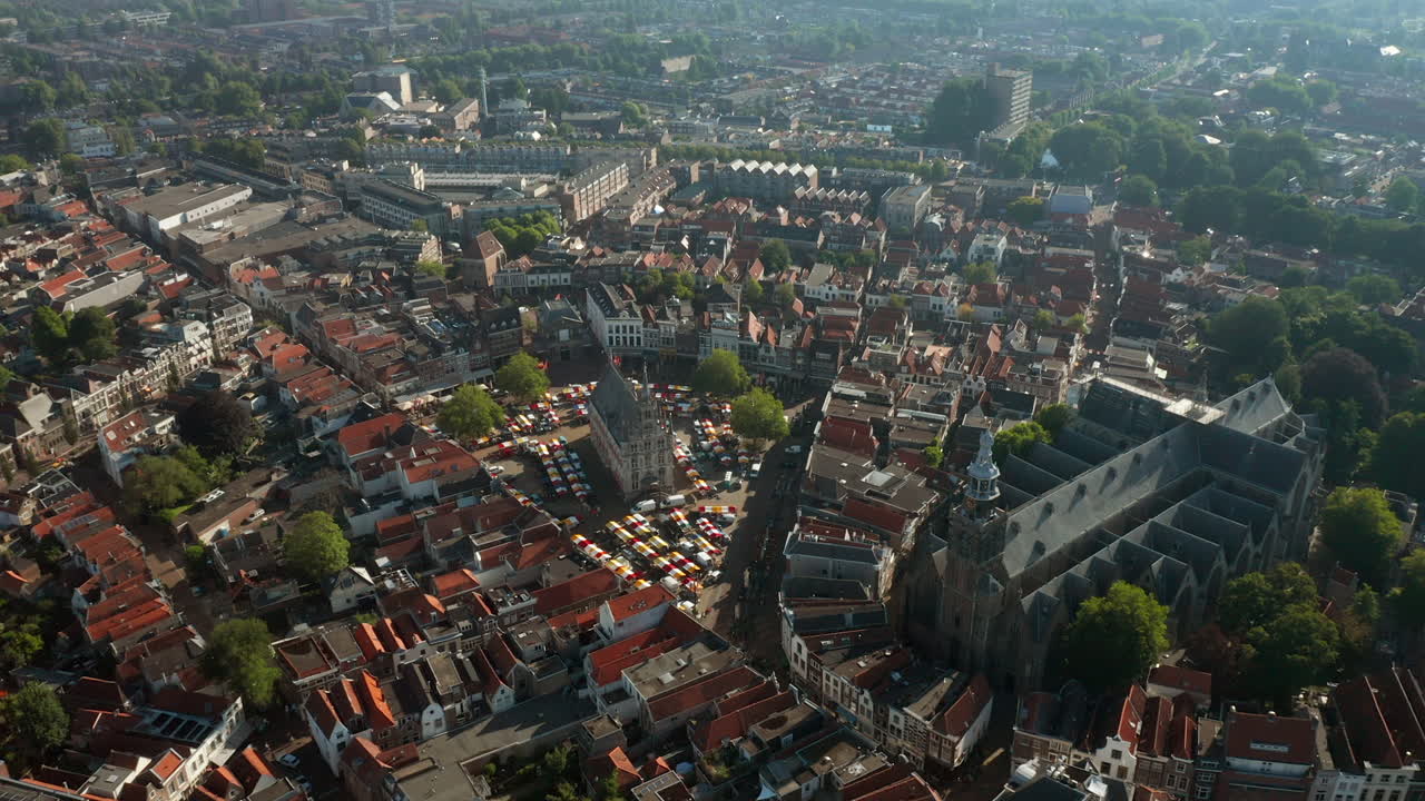 신트잔 교회의 눈에 띄는 랜드마크와 구조를 향해 날아가는 구시청사, 시장은 네덜란드 고우다 메트로폴리탄에 있습니다.