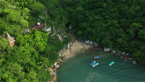 Drone-shot-tilting-toward-a-exotic-beach-in-sunny-Puerto-Vallarta,-Mexico