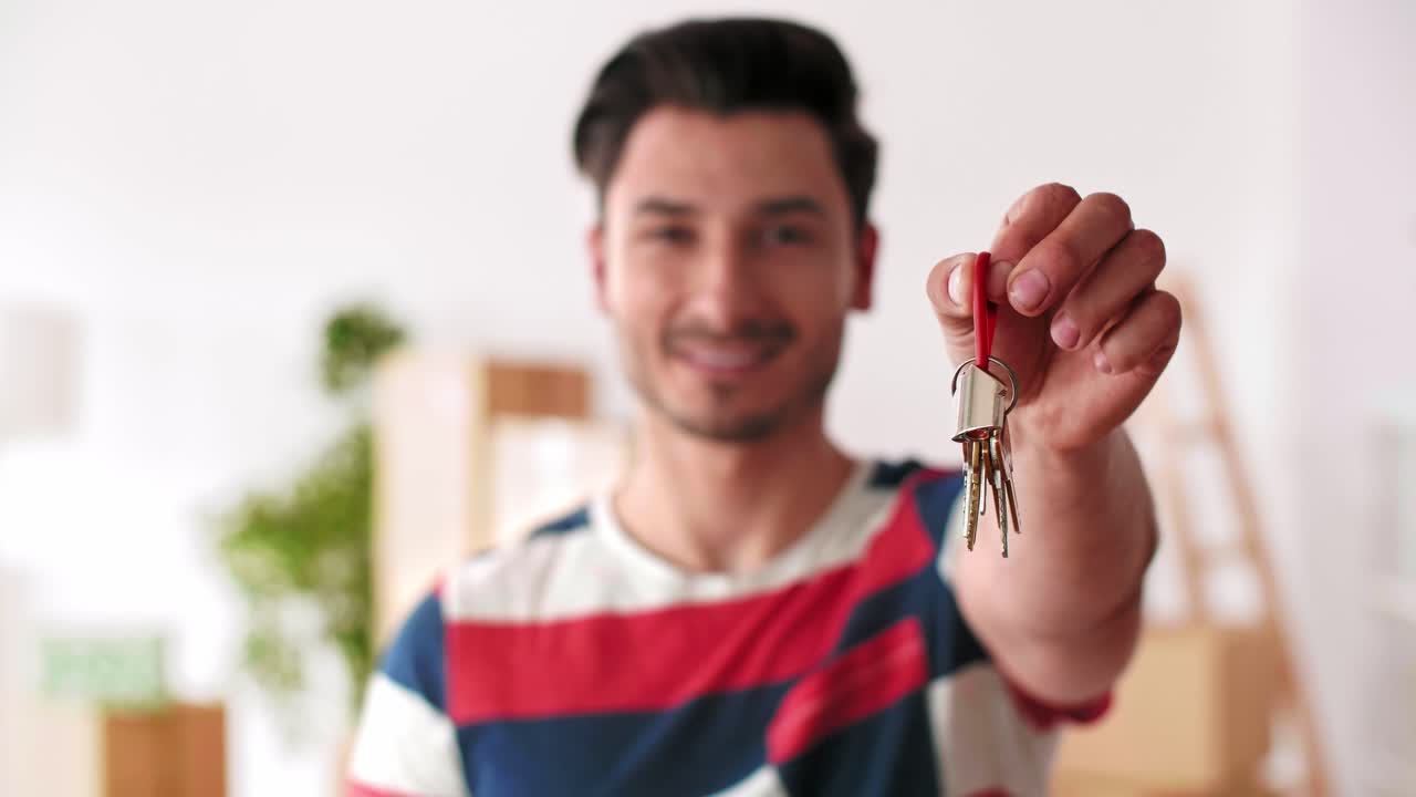 Uomo sorridente che mostra la chiave della nuova casa
