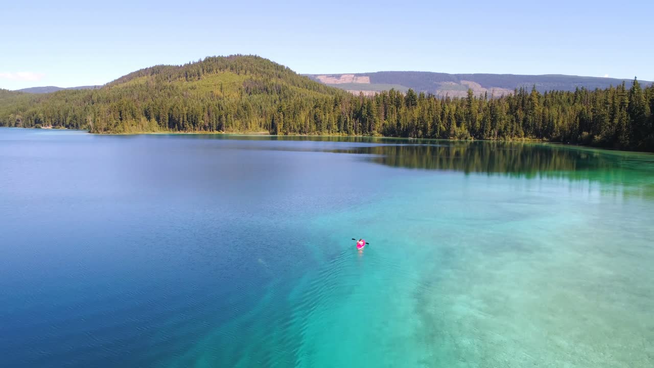 호수 4k에서 카야크를 타고 있는 여성의 공중 전망