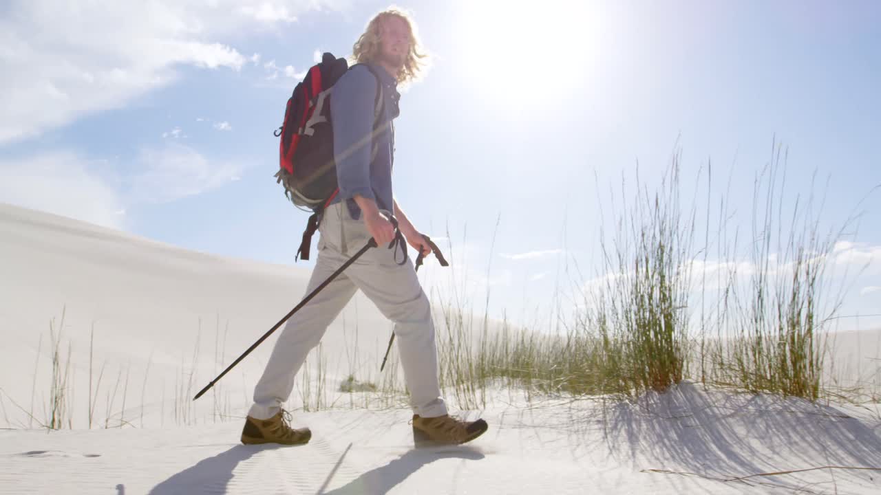 hombre con caña de senderismo caminando en el desierto 4k