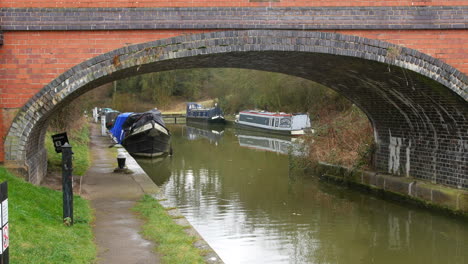 a bridge over a canal with narrow boats on the river