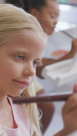 video of focused caucasian girl painting during art lessons at school